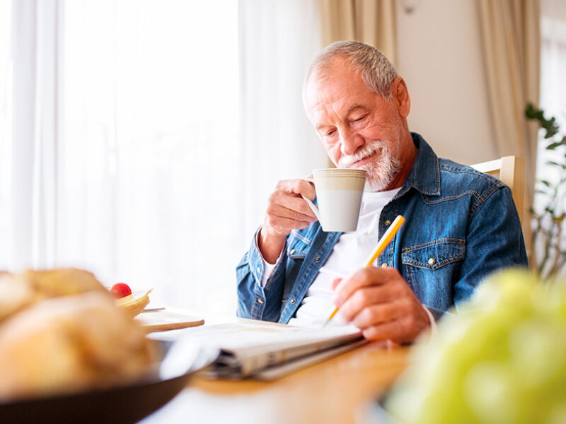 Spry Hub Monthly puzzles - man sitting doing a crossword