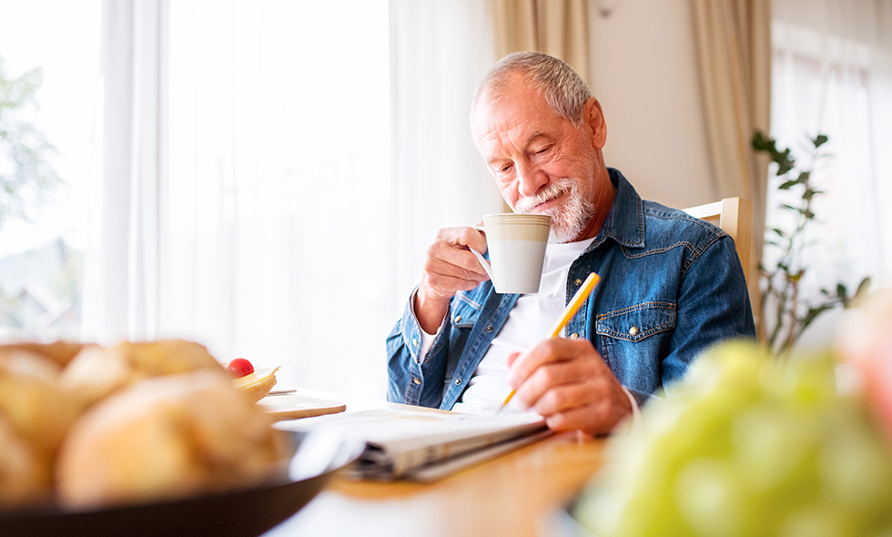 Spry Hub Monthly puzzles - man sitting doing a crossword