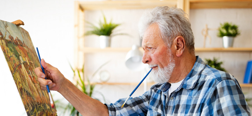 A retiree painting a canvas and enjoying their later life